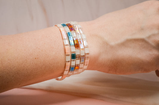 Multicolored beaded bracelet on a wrist against a neutral background