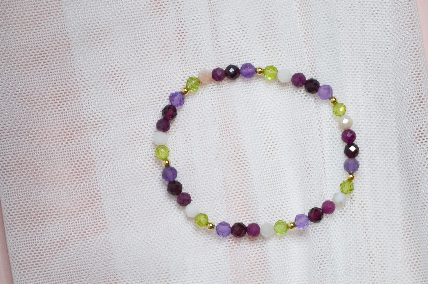 Multicolored birthstone beaded bracelet on a light fabric background