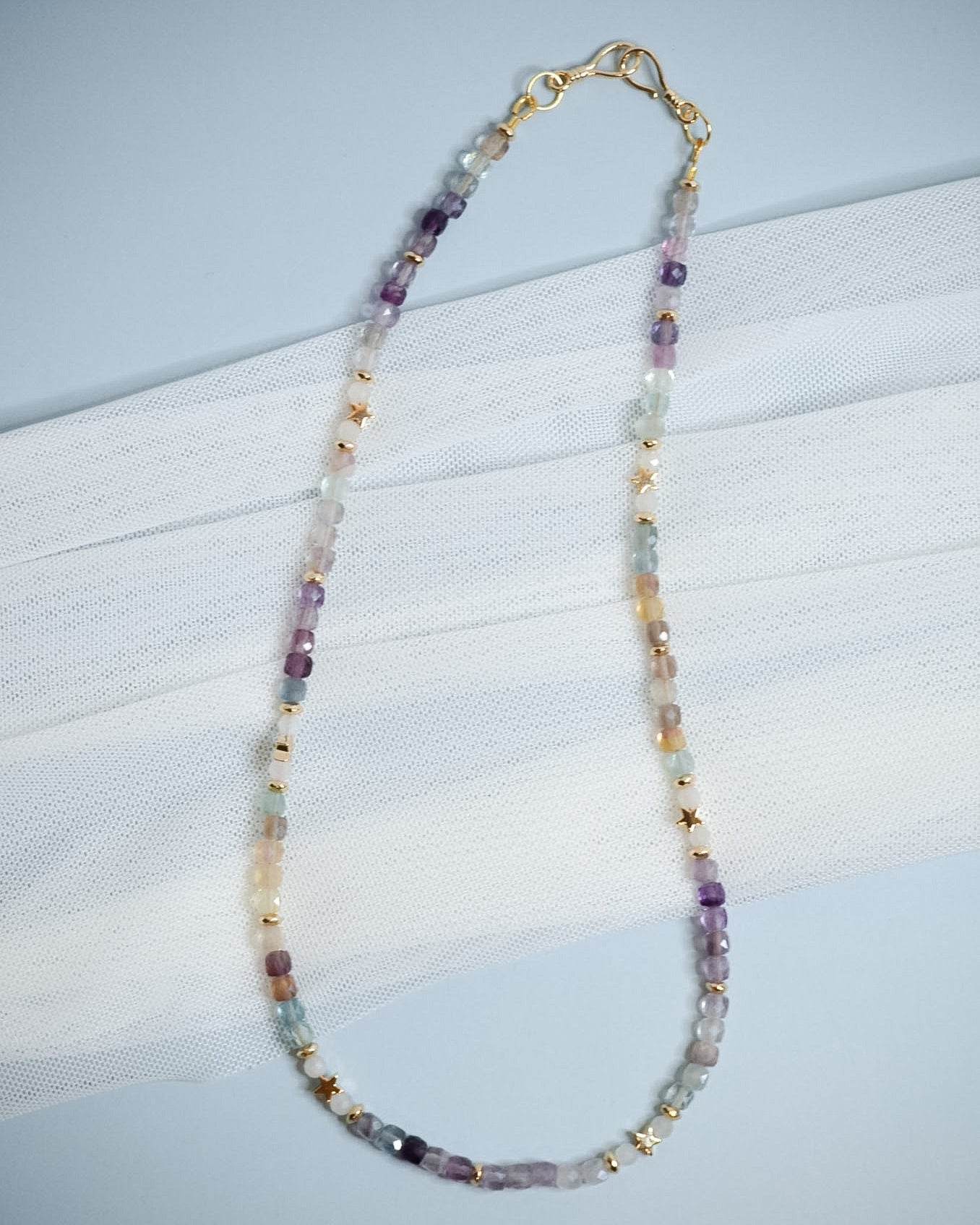Beaded necklace with multicolored beads on a light blue background