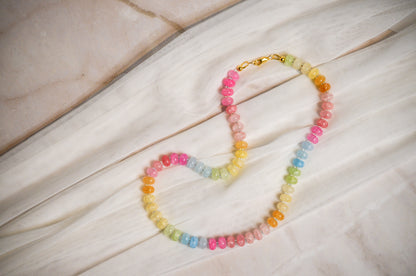 Colorful beaded necklace on a marble and white fabric