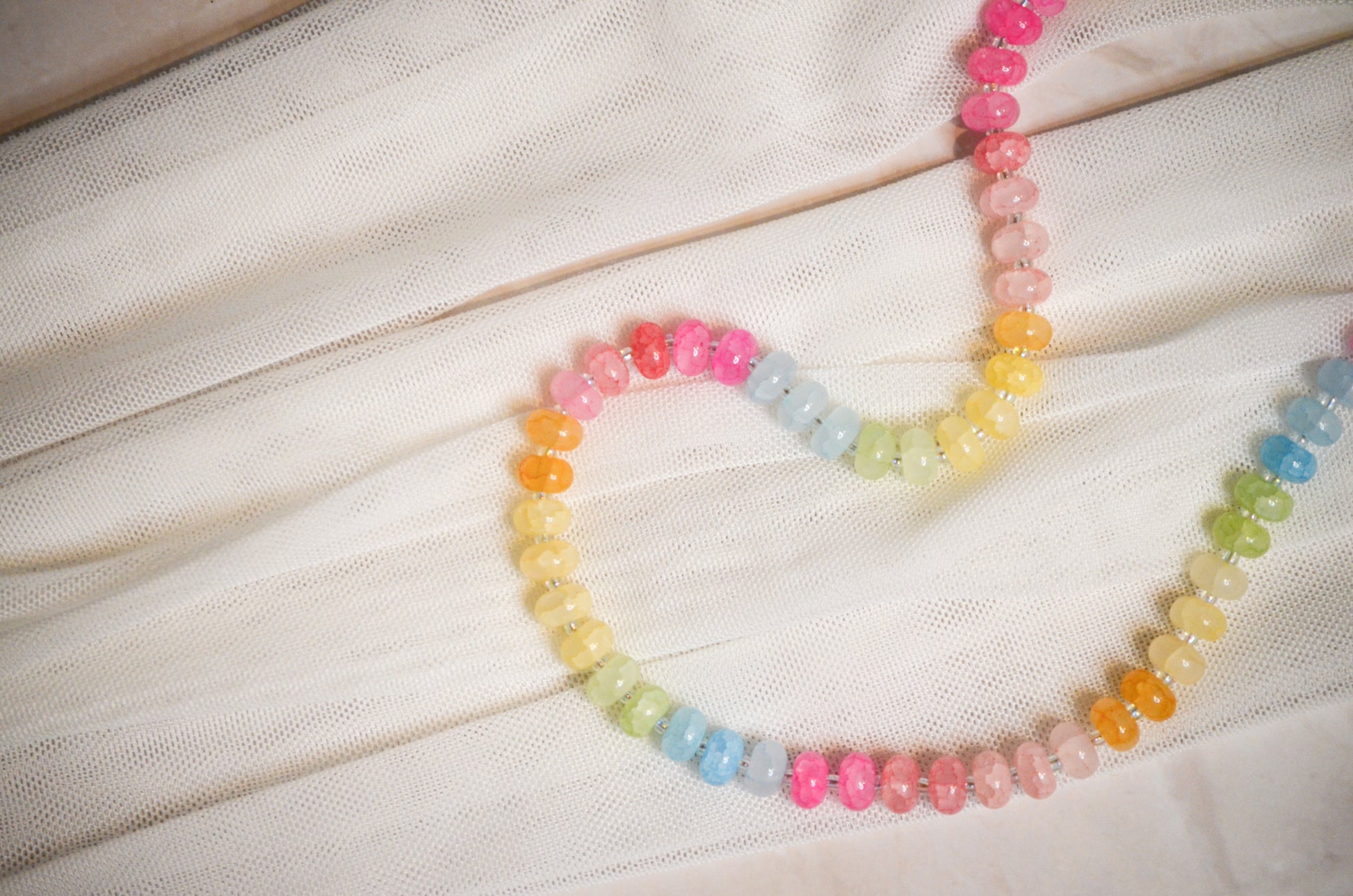 Colorful beaded necklace on a white fabric