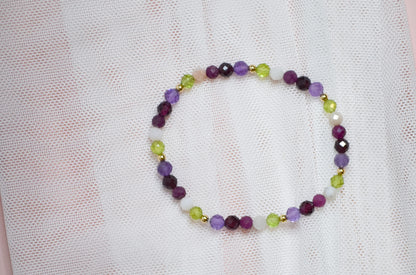 Multicolored birthstone beaded bracelet on a light fabric background