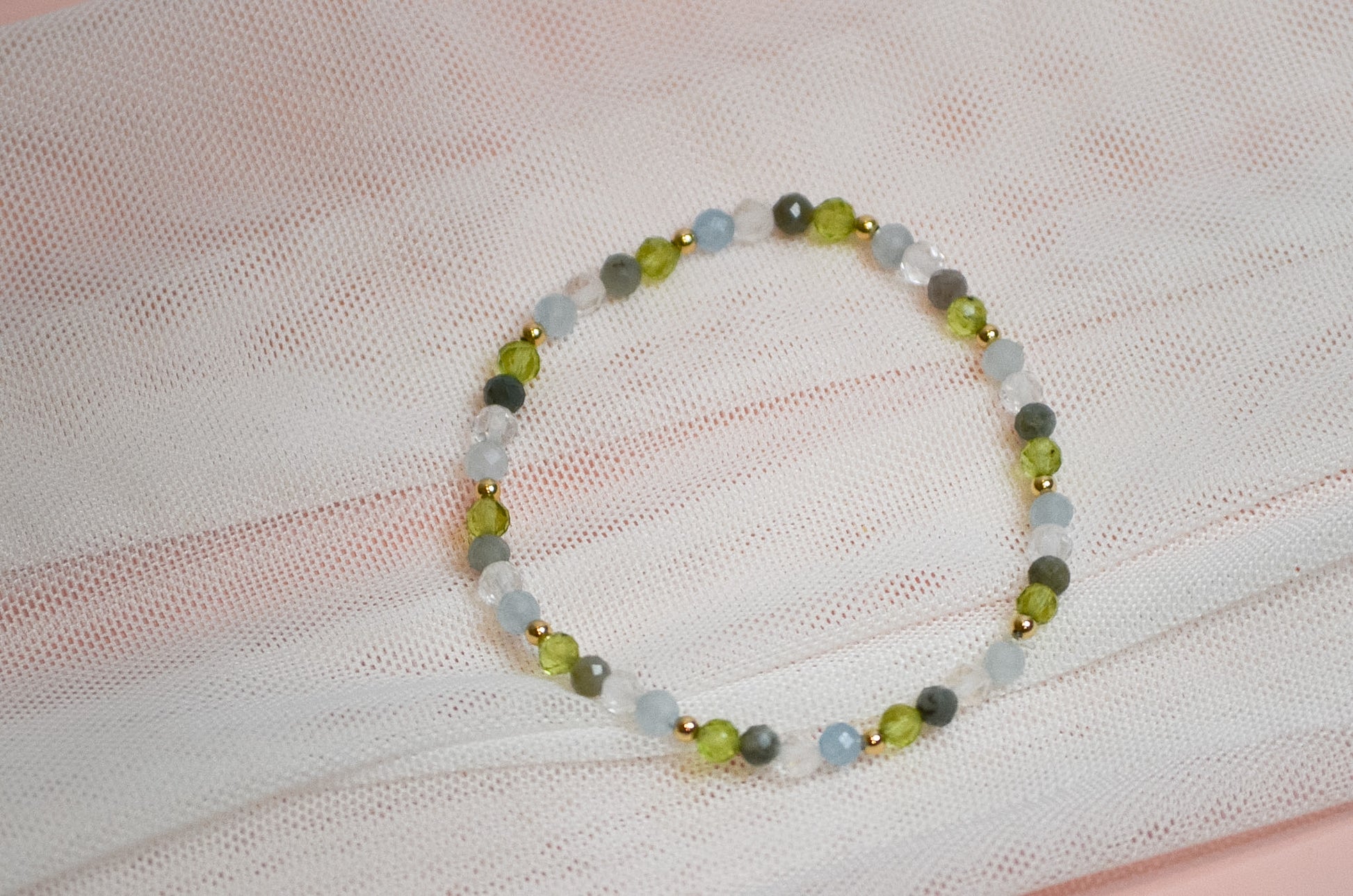 Beaded birthstone bracelet on a white fabric background