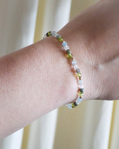 Close-up of a wrist wearing a beaded bracelet against a neutral background