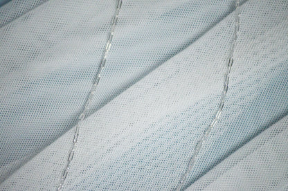 Close-up of textured fabric with a silver chain link necklace.