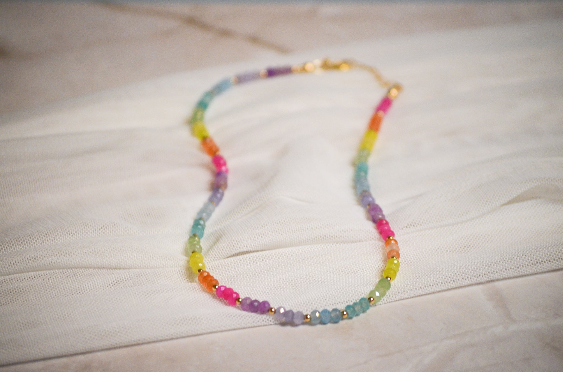 Colorful beaded necklace on a light quartz surface