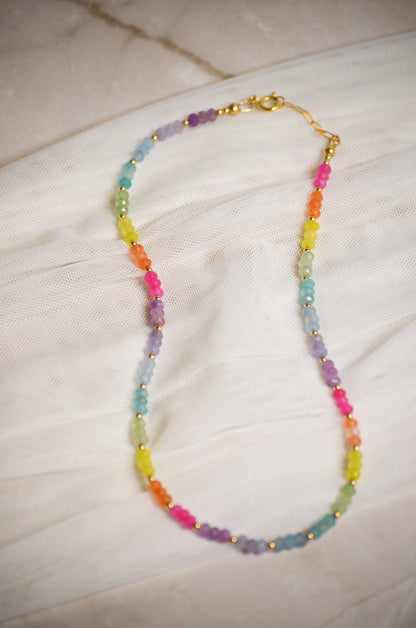 Colorful beaded necklace on a light fabric background