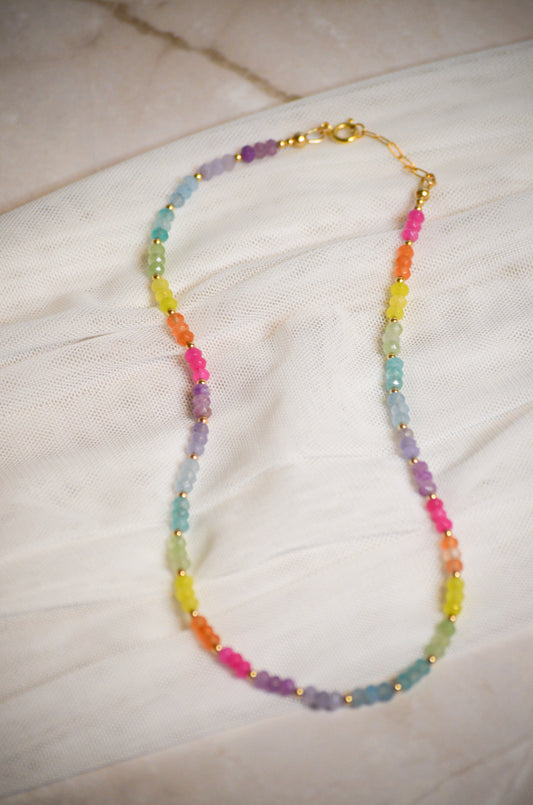 Colorful beaded necklace on a light fabric background