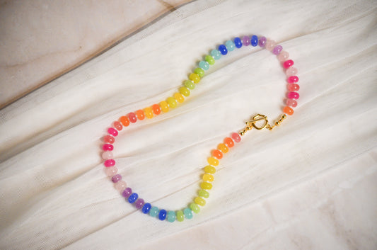 Colorful beaded necklace on a light fabric background