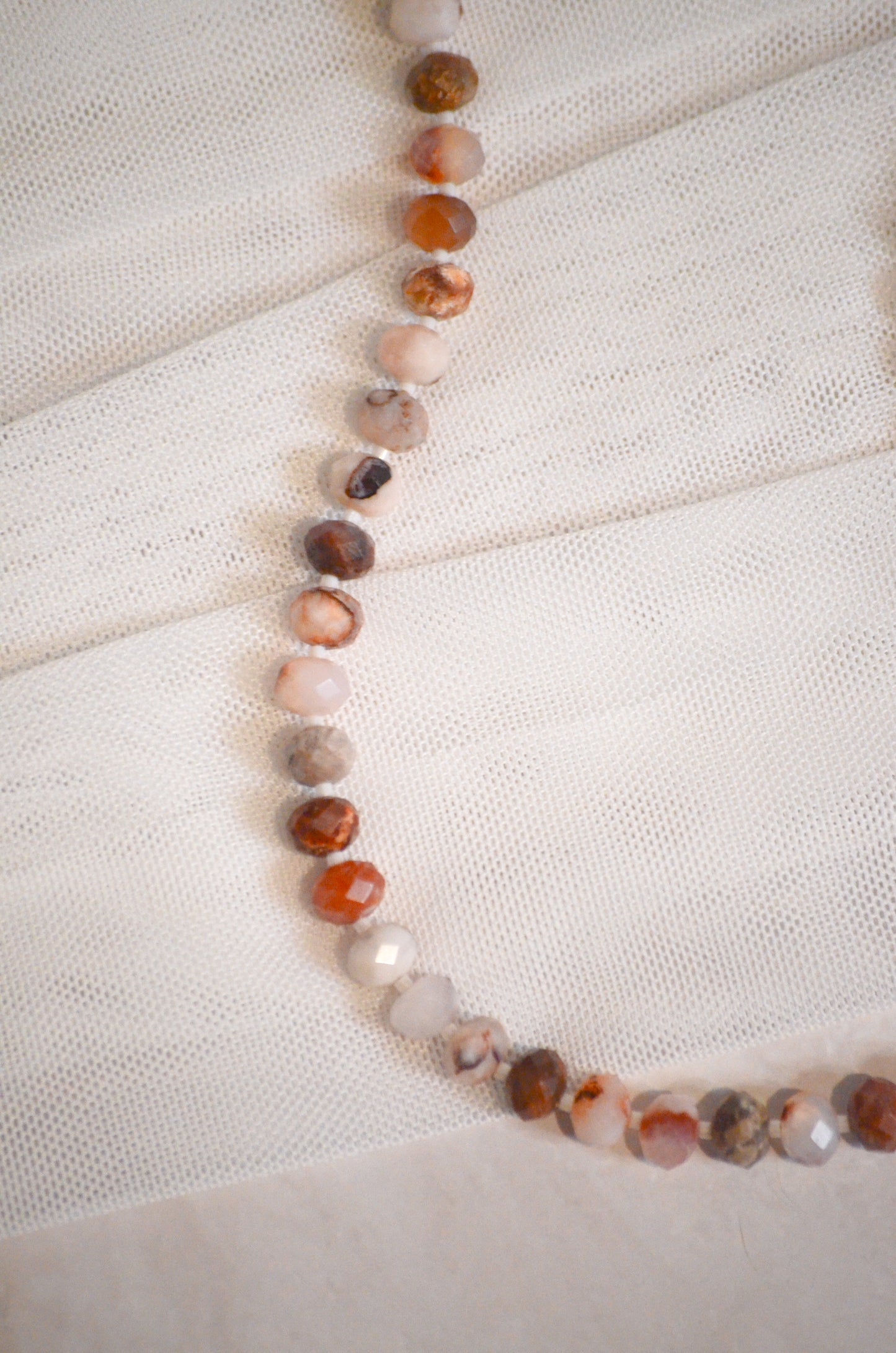 Necklace with multicolored beads on a textured white surface