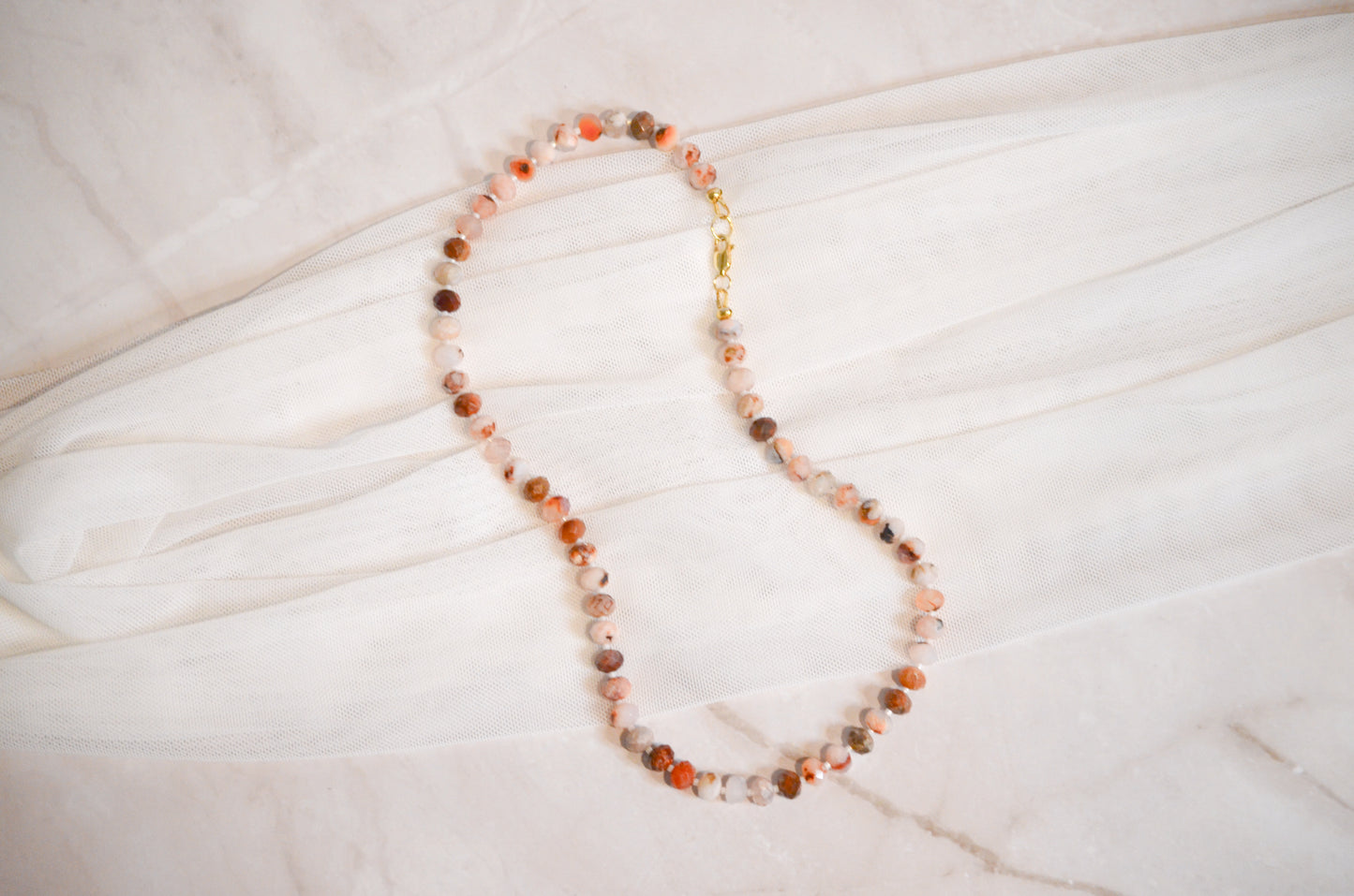 Necklace with multicolored beads on a light wooden surface