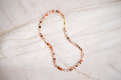 Necklace with multicolored beads on a light wooden surface