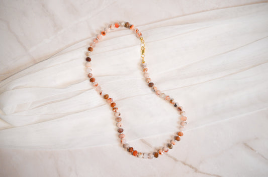 Necklace with multicolored beads on a light wooden surface