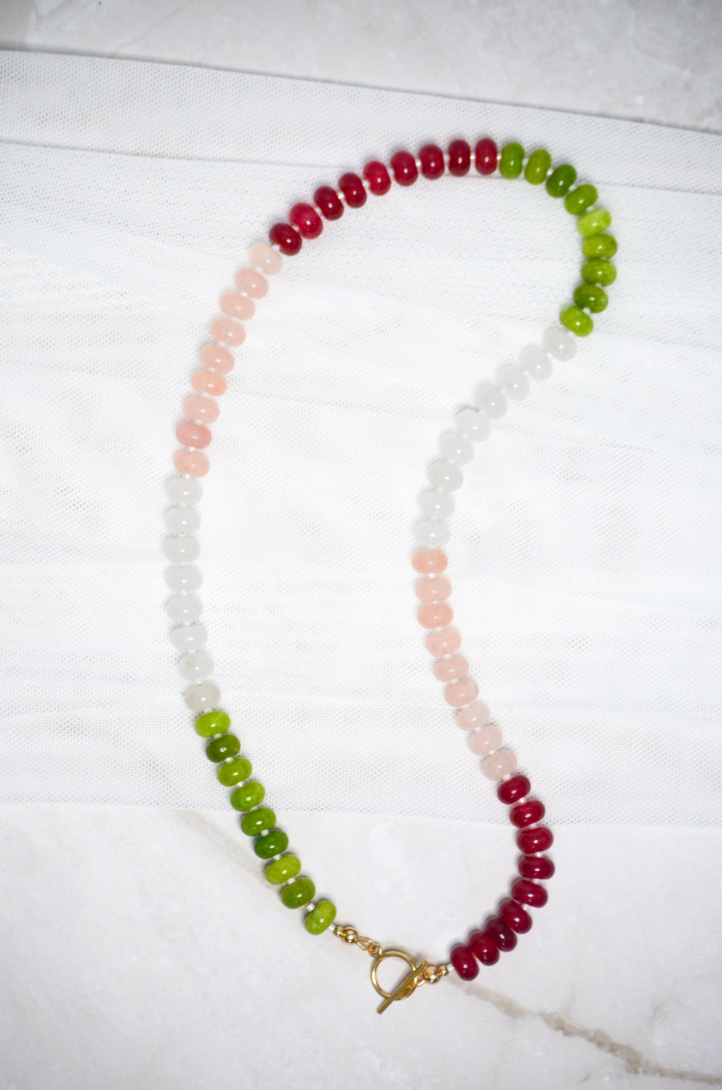 Necklace with multicolored beads on a white surface