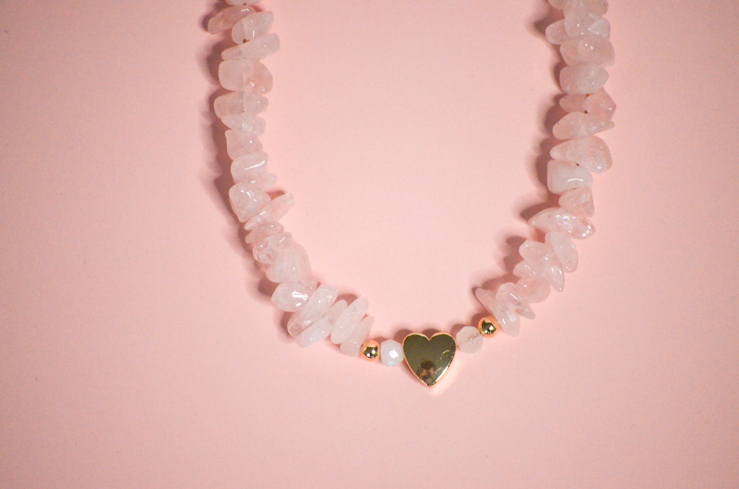 Necklace with heart-shaped pendant on a pink background