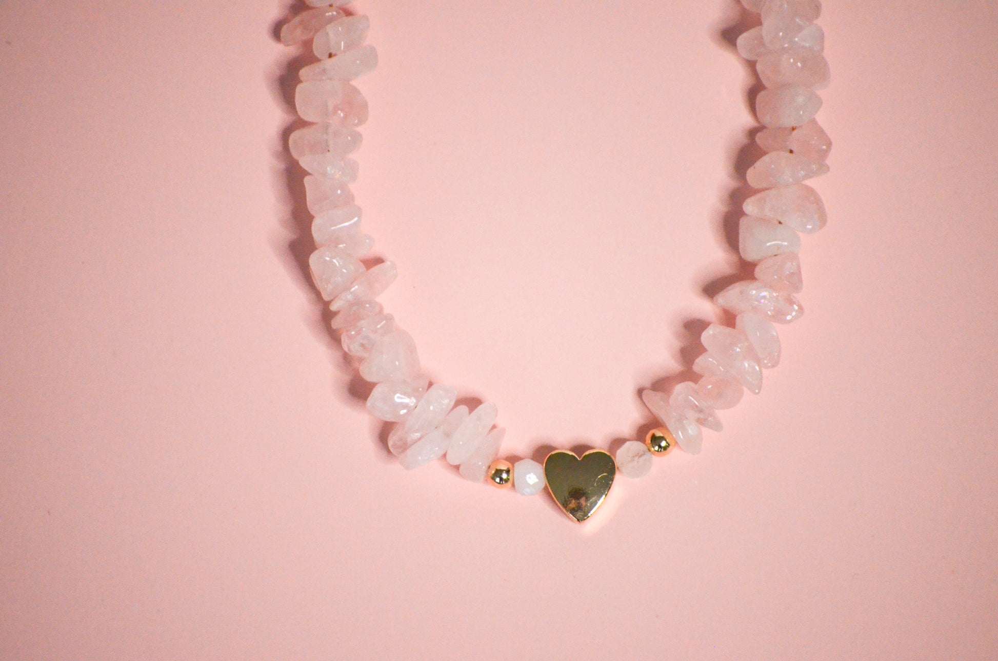 Necklace with heart-shaped pendant on a pink background